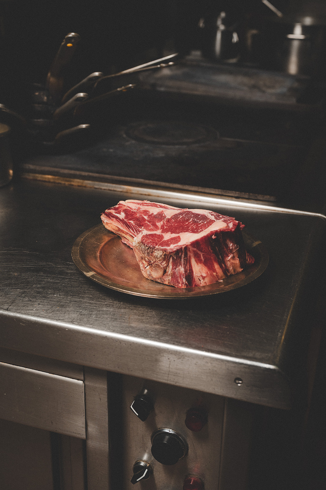 Côte de bœuf Paris 6e : pièce de Simmental crue sur un plat, en cuisine chez Joséphine Chez Dumonet